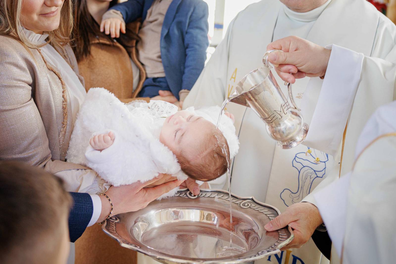 Baptism ceremony: Baby wird von einem Priester in der Kirche getauft